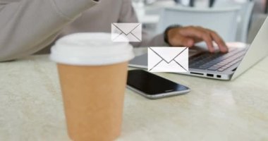 Akıllı telefon ve dizüstü bilgisayar kullanan adamın üzerindeki emoji simgelerinin animasyonu. küresel sosyal medya, bağlantılar, iletişim ve teknoloji konsepti dijital olarak oluşturulmuş video.