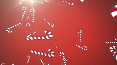 Kırmızı arkaplanda ışık noktasına düşen çoklu şeker kamışı simgeleri. Noel şenliği ve kutlama konsepti