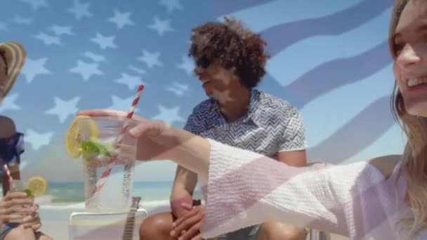 ビーチで楽しんでいる友人のグループにウサの旗を振るアニメーション 愛国心とお祝いの概念デジタルで生成されたビデオ — ストック動画