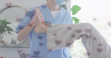 Kafkasyalı yaşlı kadın ve yüz maskesi takan hemşire üzerindeki kovid virüs hücrelerinin animasyonu. küresel covid 19 salgın konsepti dijital olarak oluşturulmuş video.