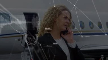 Kafkasyalı iş kadınının havaalanında akıllı telefondan konuştuğu ağların animasyonu. küresel bağlantılar, veri işleme ve dijital arayüz konsepti dijital olarak oluşturulmuş video.