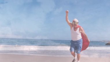 Plajda süper kahraman kostümü giyen yaşlı beyaz adamın üzerindeki bulutların animasyonu. eğlence ve eğlence konsepti dijital olarak oluşturulmuş video.