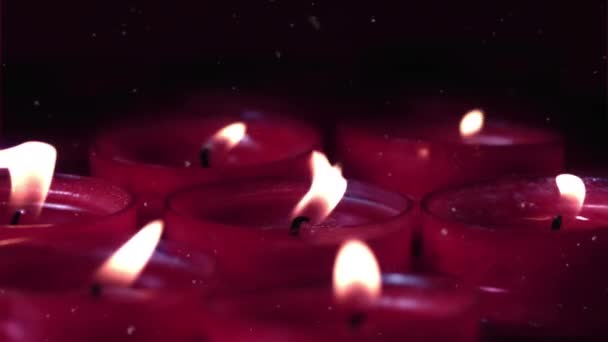 白色粒子在黑色背景下与燃烧的红色蜡烛相映成趣 庆祝和庆祝概念 — 图库视频影像