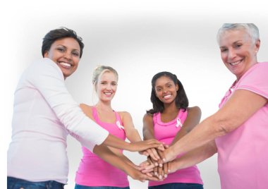 Çeşitli kadın gruplarının portresi ellerini birleştirip gri arka plana gülümsüyor. Göğüs kanseri farkındalığı kavramı