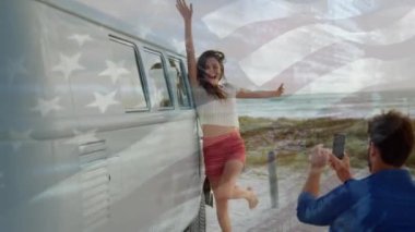 Sahilde eğlenen çiftin üzerinde Amerikan bayrağı sallaması. seyahat, tatiller, vatanseverlik ve dijital olarak üretilen video konsepti.
