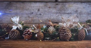 Çam kozalaklarıyla süslenmiş yılbaşı süslemeleri üzerine ışık kompozisyonu. Noel, gelenek ve kutlama konsepti dijital olarak oluşturuldu.