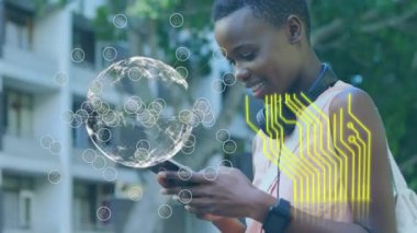 Akıllı telefon kullanan Afrikalı Amerikalı bir kadın üzerinde bilgisayar devre kartı ve dünyanın animasyonu. küresel iletişim, veri paylaşımı ve dijital arayüz kavramı, dijital olarak oluşturulmuş video.