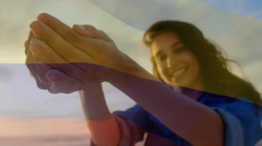 Sahilde eğlenen bir kadının üzerine Kolombiya bayrağı sallamanın animasyonu. seyahat, tatiller, vatanseverlik ve dijital olarak üretilen video konsepti.