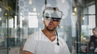 VR kulaklık takan Afrikalı Amerikalı bir adamın sosyal medya simgelerinin ve veri işleme programının animasyonu. küresel dijital arayüz, teknoloji ve sosyal medya konsepti dijital olarak oluşturulmuş video.