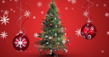 Kırmızı arka planda Noel süsleri ve Noel ağacı üzerine yağan kar animasyonu. Noel, gelenek ve kutlama konsepti dijital olarak oluşturuldu.