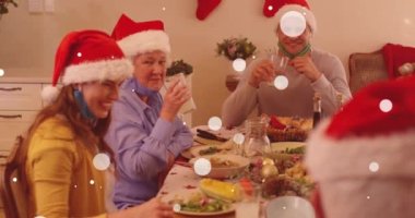 Noel 'de akşam yemeği sırasında mutlu beyaz bir ailenin üzerine yağan kar animasyonu. Noel, kış, gelenek ve kutlama konsepti dijital olarak oluşturulmuş video.