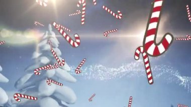 Mutlu bayramlar mesajı ve kış manzarasında Noel ağacının üzerine düşen çoklu şeker kamışı ikonları. Noel şenliği ve kutlama konsepti