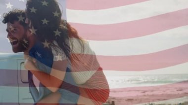 Sahilde eğlenen çiftin üzerinde Amerikan bayrağı sallaması. seyahat, tatiller, vatanseverlik ve dijital olarak üretilen video konsepti.