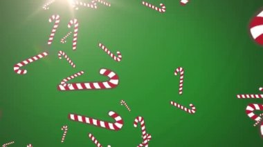 Yeşil arka planda ışık noktasına düşen çoklu şeker kamışı simgeleri. Noel şenliği ve kutlama konsepti