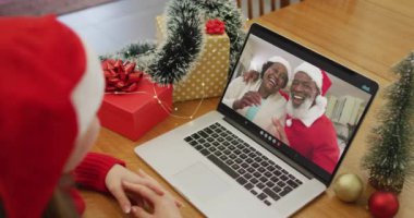 Noel 'de üst düzey bir çiftle görüntülü görüşme yapan mutlu beyaz kadın. Noel, şenlik ve iletişim teknolojisi.