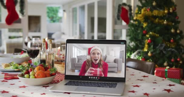 坐在笔记本电脑上戴着圣诞礼帽的快乐的高加索女人躺在圣诞桌上 圣诞节 节日和通信技术 — 图库视频影像