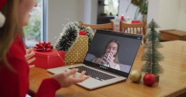 Mutlu Kafkasyalı kadın Noel zamanı bayan arkadaşıyla görüntülü konuşma yapıyor. Noel, şenlik ve iletişim teknolojisi.