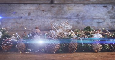 Çam kozalaklarıyla süslenmiş yılbaşı süslemeleri üzerine ışık kompozisyonu. Noel, gelenek ve kutlama konsepti dijital olarak oluşturuldu.