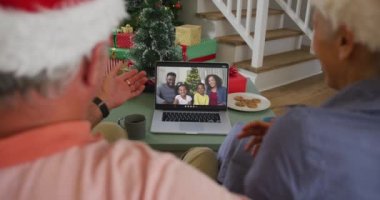 Laptop 'taki mutlu Kafkasyalı yaşlı çift Noel zamanı ailesiyle görüntülü konuşma yapıyor. Noel, şenlik ve iletişim teknolojisi.
