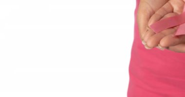Pembe beşik takmış, pembe kanser kurdelesi takmış bir kadının elleri. Göğüs kanseri pozitif farkındalık kampanyası konsepti dijital olarak üretildi.
