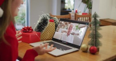 Noel 'de büyükanneyle görüntülü görüşme yapan Kafkasyalı mutlu bir kadın. Noel, şenlik ve iletişim teknolojisi.