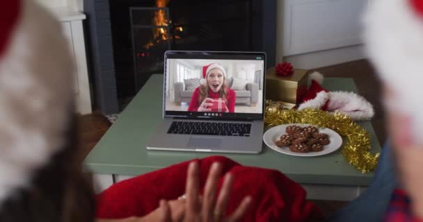 クリスマスの時に女性の友人とラップトップでビデオ通話で白人のカップル クリスマスやお祭りや通信技術は — ストック動画