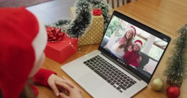 Beyaz kadın, Noel 'de kız arkadaşı ve kızıyla görüntülü görüşme yapıyor. Noel, şenlik ve iletişim teknolojisi.