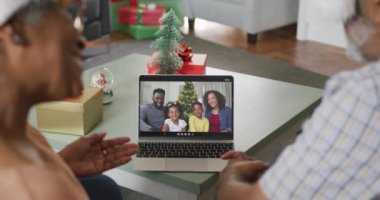 Mutlu Afro-Amerikan son sınıf çifti Noel 'de ailesiyle görüntülü konuşma yapıyor. Noel, şenlik ve iletişim teknolojisi.