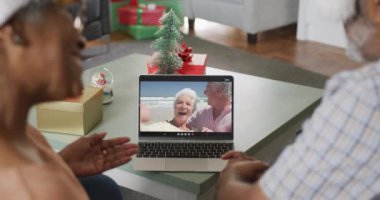 Mutlu son sınıf Afro-Amerikan çifti Noel 'de arkadaşlarıyla görüntülü konuşma yapıyor. Noel, şenlik ve iletişim teknolojisi.