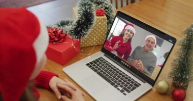 Bilgisayardaki beyaz kadın, Noel zamanı bayan arkadaşı ve yaşlı babasıyla görüntülü konuşma yapıyor. Noel, şenlik ve iletişim teknolojisi.