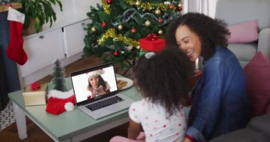 Mutlu Afro-Amerikan anne ve kızı, Noel 'de kız arkadaşıyla birlikte dizüstü bilgisayardan arıyor. Noel, şenlik ve iletişim teknolojisi.