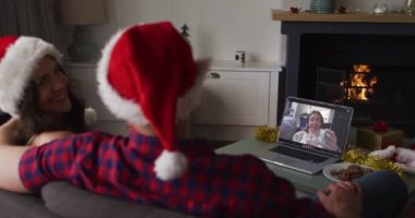 Laptop 'taki beyaz çift Noel zamanı bayan arkadaşıyla görüntülü görüşme yapıyor. Noel, şenlik ve iletişim teknolojisi.
