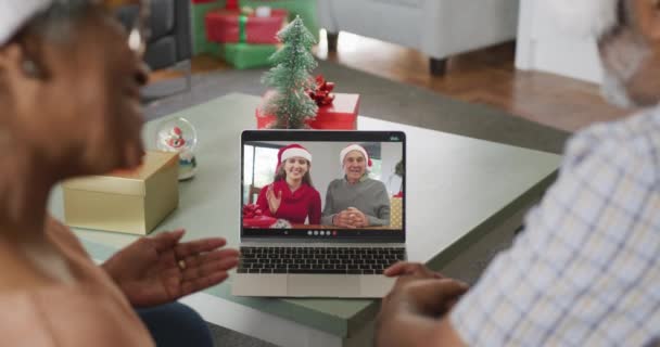 クリスマスに先輩の友達とビデオ通話で幸せなアフリカ系アメリカ人のシニアカップル クリスマスやお祭りや通信技術は — ストック動画
