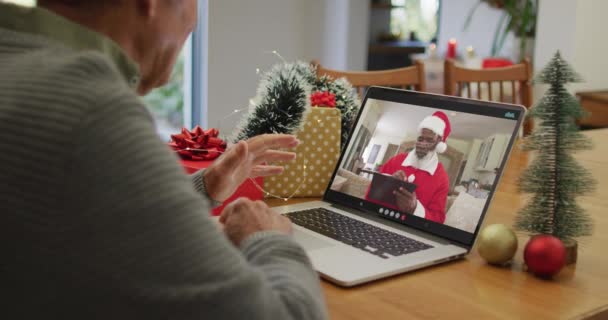 白人老人在笔记本电脑上有圣诞视频电话 屏幕上有非洲裔美国人的圣塔 圣诞节 节日和通信技术 — 图库视频影像
