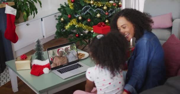 圣诞节期间 非裔美国人的母亲和女儿在电视上与祖父母通话 圣诞节 节日和通信技术 — 图库视频影像