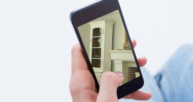 Oturma odasının içi ekranda gösterilen akıllı telefonu kullanan kişinin görüntüsü. Çevrimiçi alışveriş evi dekorasyonu konsepti dijital kompozit.