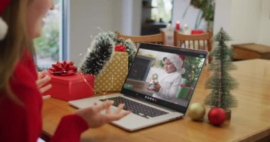 Noel 'de oğluyla görüntülü görüşme yapan Kafkasyalı mutlu kadın. Noel, şenlik ve iletişim teknolojisi.