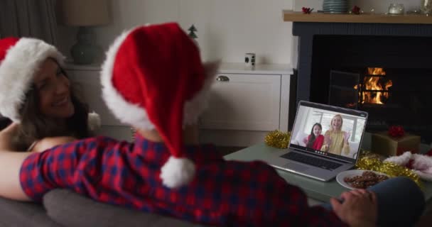 白人のカップルは クリスマス時に女性の友人と彼女の娘とビデオ通話で クリスマスやお祭りや通信技術は — ストック動画