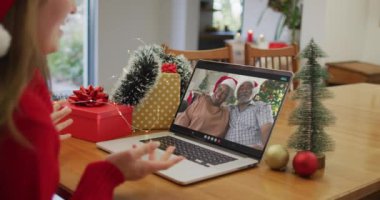 Noel 'de üst düzey bir çiftle görüntülü görüşme yapan mutlu beyaz kadın. Noel, şenlik ve iletişim teknolojisi.