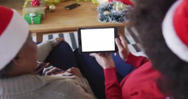 Afrika kökenli Amerikalı anne ve kızı, tablet Noel görüntülü konuşma yapıyor, ekranda boşluğu kopyalıyor. Noel, şenlik ve iletişim teknolojisi.
