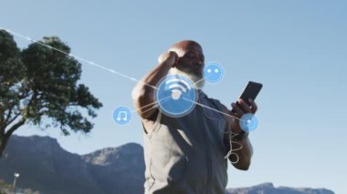Sahilde akıllı telefon kullanan kıdemli Afro-Amerikan bir adam üzerinden bağlantı ağının animasyonu. sağlıklı, aktif yaşam tarzı, bağlantılar ve dijital arayüz konsepti dijital olarak oluşturulmuş video.