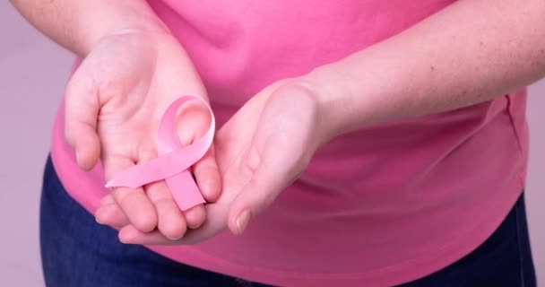 拿着粉红癌症意识带的高加索女人的中间部分视频 乳腺癌积极认识运动概念 — 图库视频影像