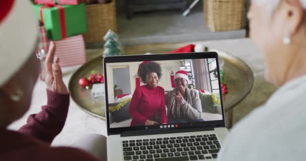 高级不同的女性朋友使用笔记本电脑与微笑的朋友在屏幕上的圣诞视频通话 圣诞节 节日和通信技术 — 图库视频影像