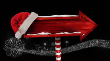 Noel 'de kar yağarken üzerinde Noel Baba şapkası olan ahşap tabela animasyonu. Noel, kış, gelenek ve kutlama konsepti dijital olarak oluşturulmuş video.