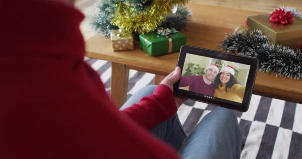 クリスマスのビデオ通話にタブレットを使用して白人男性 画面上の笑顔の友人と クリスマスやお祭りや通信技術は — ストック動画