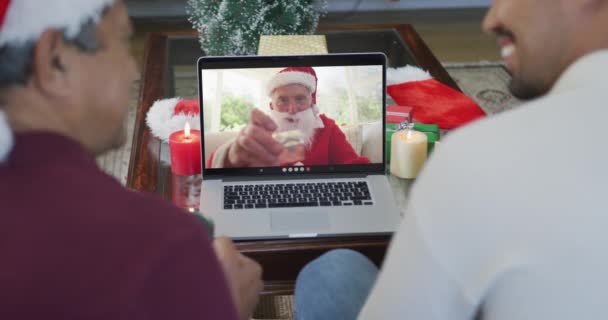 画面上のサンタとクリスマスのビデオ通話のためのラップトップを使用して出産の父と息子を笑顔 クリスマスやお祭りや通信技術は — ストック動画