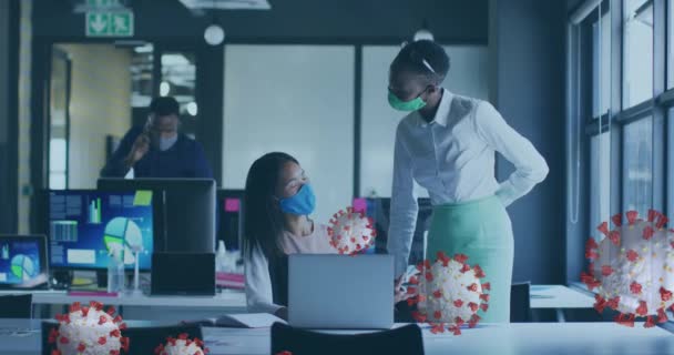 在办公室使用手提电脑为不同的带口罩的女商人制作病毒细胞动画 Covid期间的全球业务和数字接口 — 图库视频影像