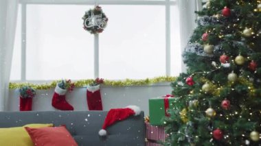 Arka planda, Noel ağacının üzerine düşen kar ve yılbaşı çoraplarının animasyonu. Noel, gelenek ve kutlama konsepti dijital olarak oluşturuldu.