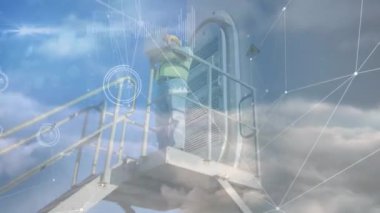 Arka planda rüzgar türbini ve erkek mühendis üzerindeki bağlantı ağının animasyonu. Rüzgar enerjisi, sürdürülebilirlik ve ekoloji konsepti dijital olarak oluşturulmuş video.