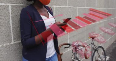 Afro-Amerikan kadın yüz maskesi takan akıllı telefon kullanan Afro-Amerikan kadınlarına ait Coperid 19 hücre ve istatistiklerin animasyonu. küresel covid 19 salgın konsepti dijital olarak oluşturulmuş video.